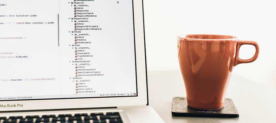 A mug sitting next to a computer.